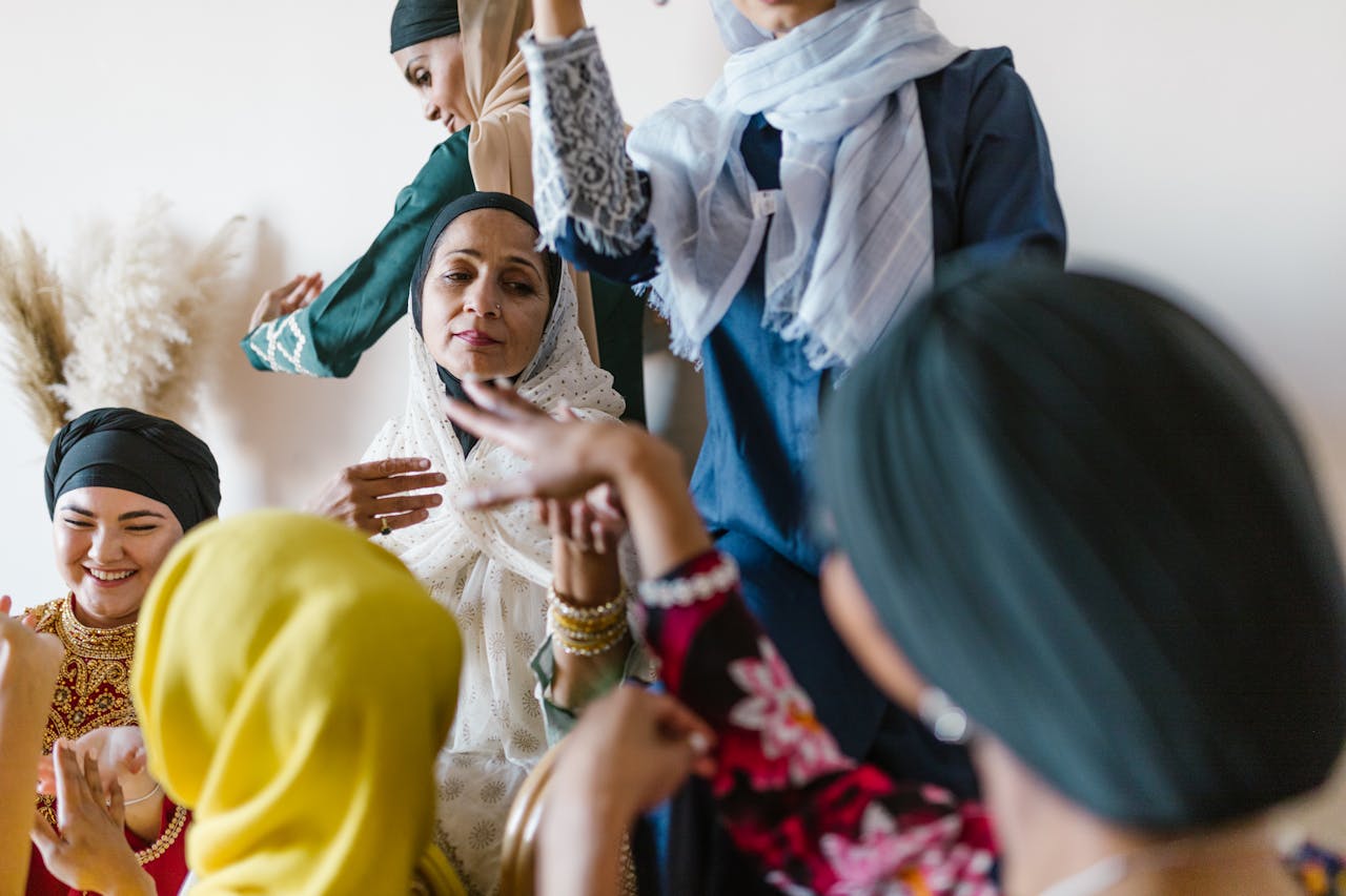 Services Group of diverse Muslim women in colorful attire celebrating and enjoying each other's company.